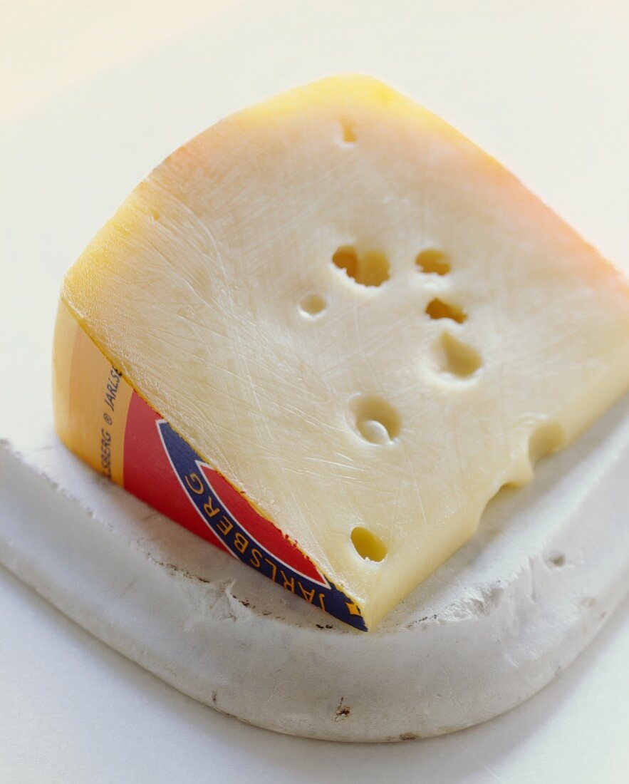 Ein Stück Jarlsberg-Käse auf einem Schneidebrett