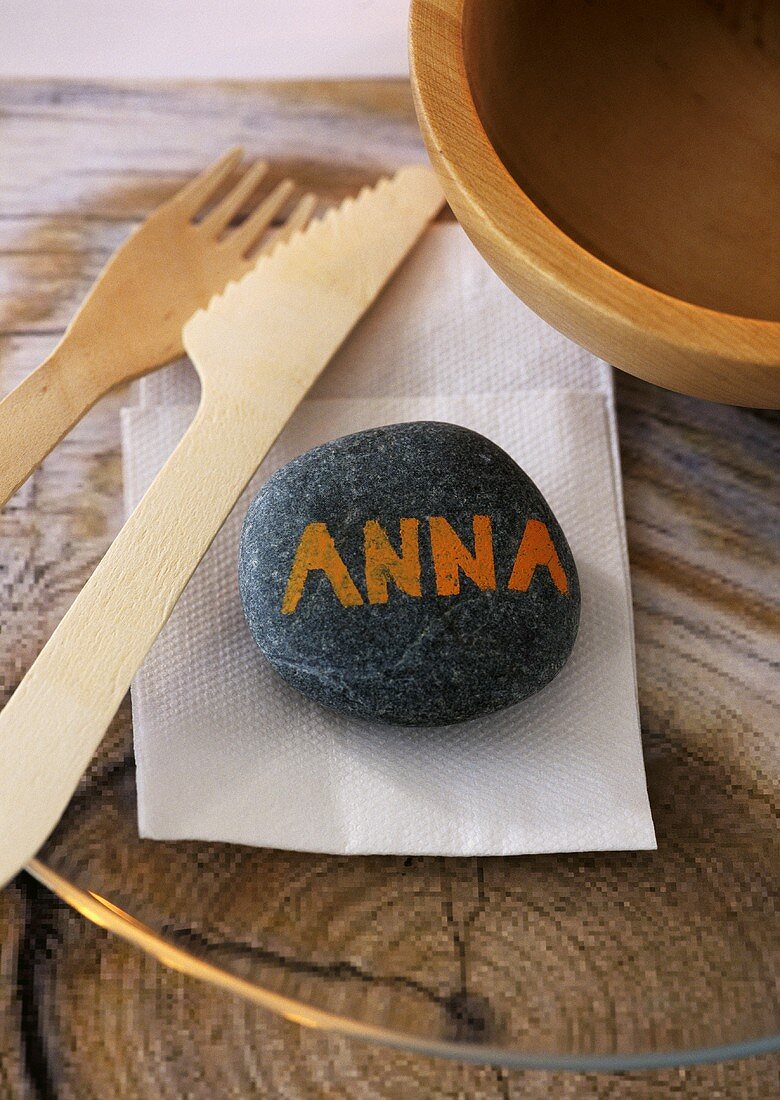 A stone as a place card, serviette and wooden cutlery