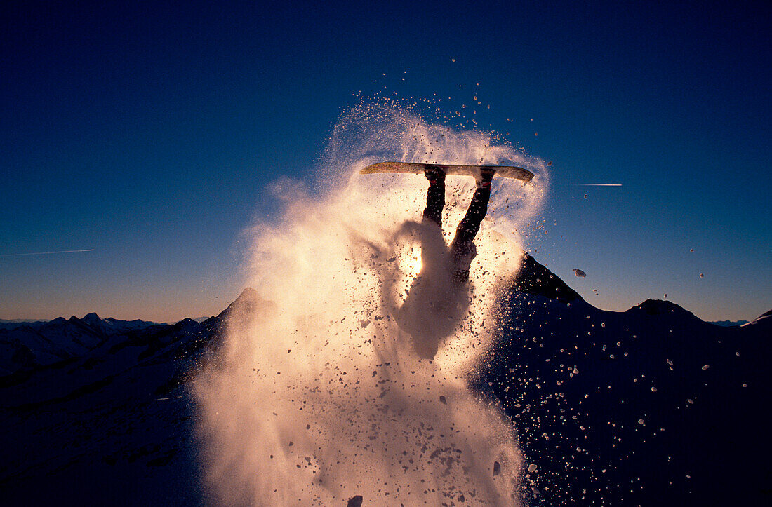 Ein Snowboarder springt Rückwärtsrolle, Tirol, Österreich