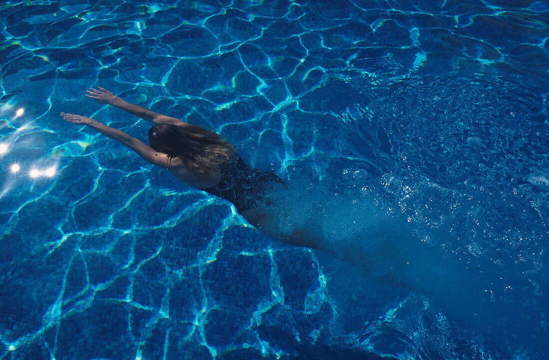 Frau taucht im Pool im La Manga Resort, Spanien, Europa