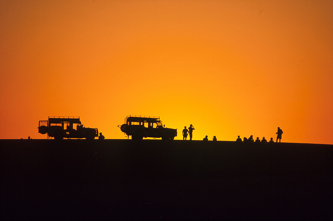 Jeeps and people at sunset, Walvis Bay, Namibia, Africa