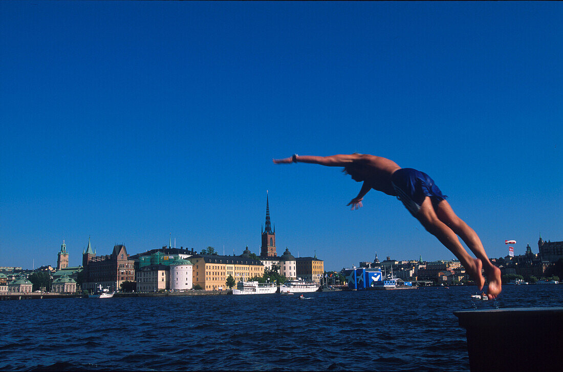 Junge springt ins Wasser des Hafens, Stockholm, Schweden, Europa