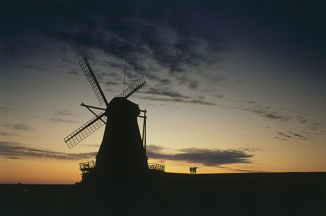 Three people at Nordermuehle, dusk, Pellworm, Schleswig-Holstein, Germany