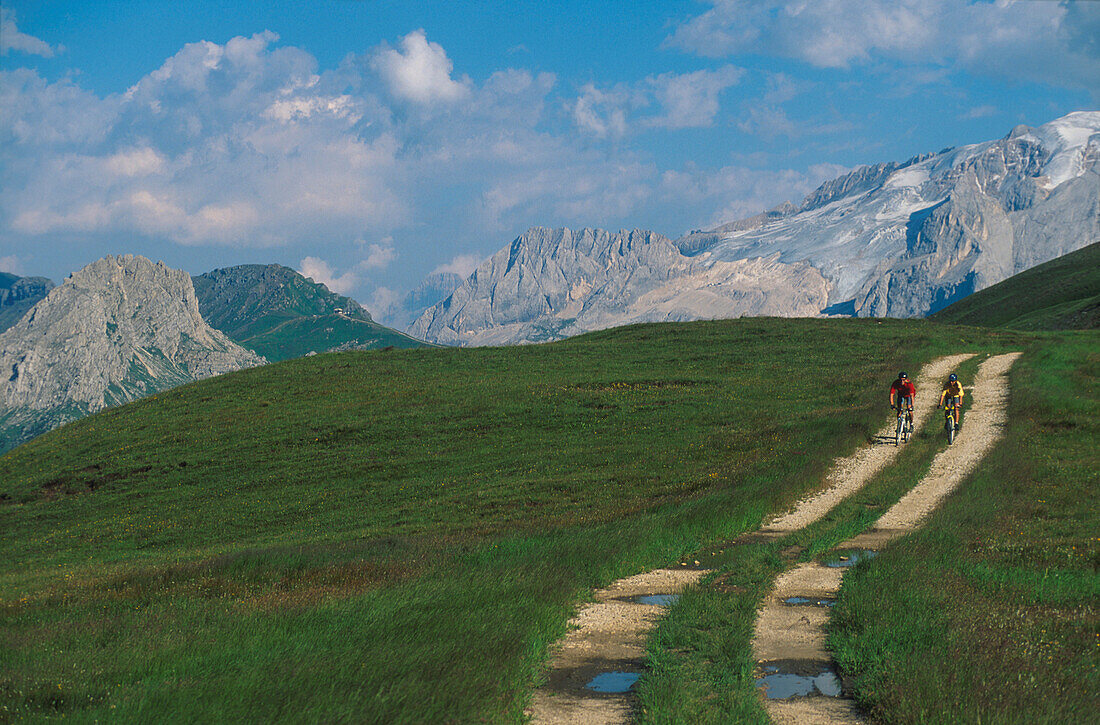 Two person on mountain bikes before mountain scenery