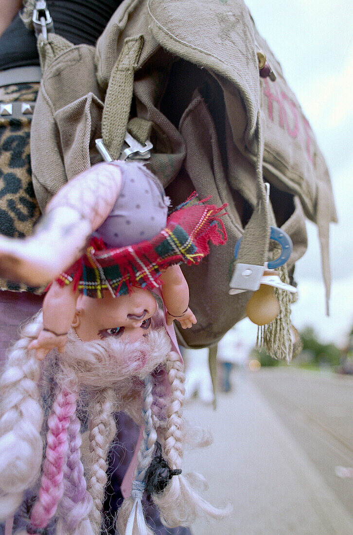 Doll hanging from backpack of teenage punk, Germany