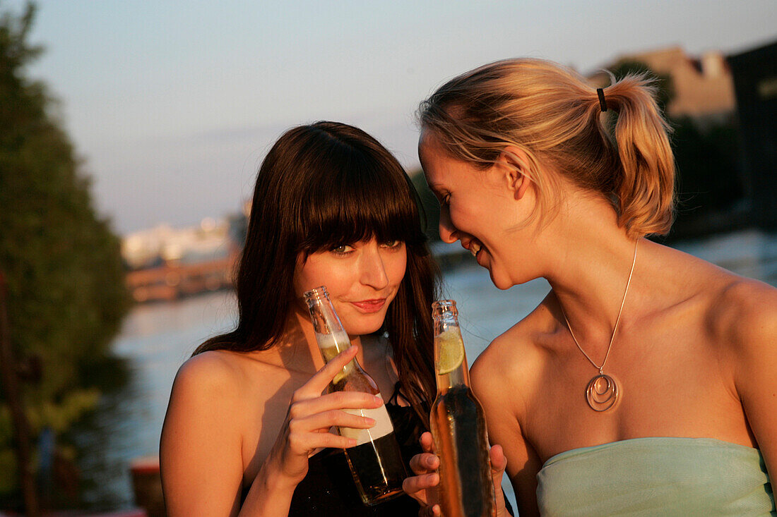 Two young women drinking beer, Berlin, Germany