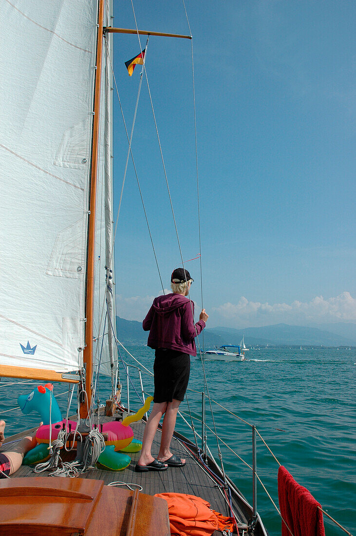 Young man watching on sailing boat, Lake of Constance, Germany