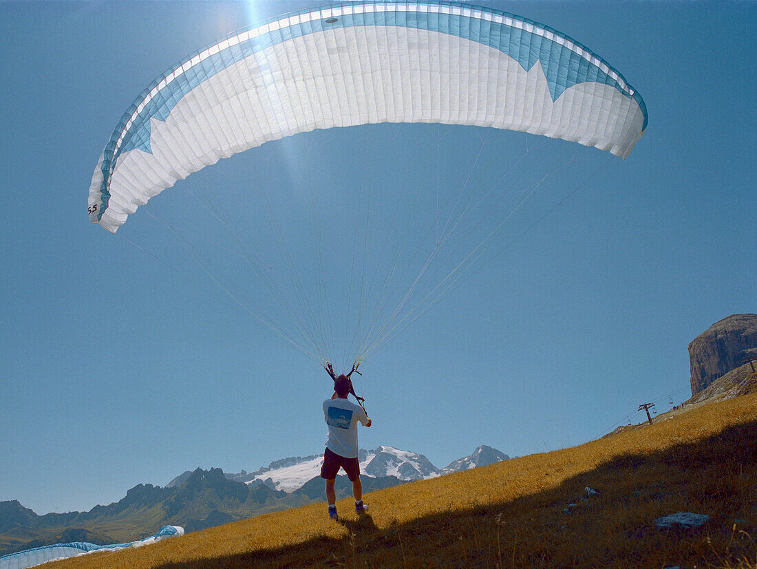 Paragliding, preparing for start, near Corvara, Dolomites, Alta Badia South Tyrol. Italy