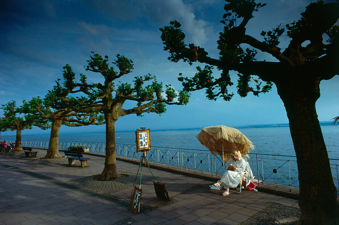 One woman sitting under a umbrella, Boardwalk of Meersburg, Lake of Constance, Germany