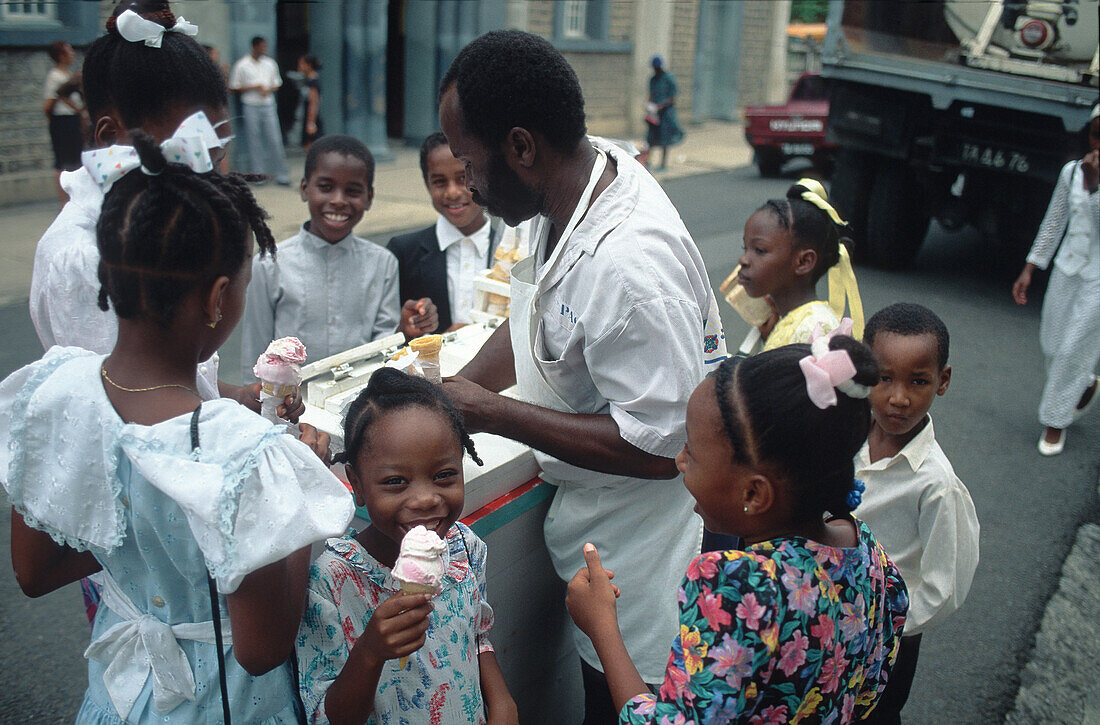 Salesman giving children ice cream, St. Lucia, Caribbean