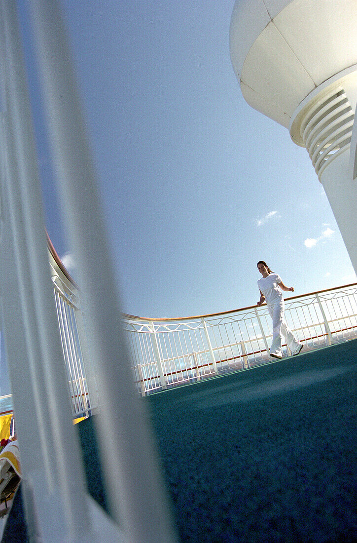 Junge Frau läuft an Deck des Kreuzfahrtschiffs AIDA, Karibik, Amerika