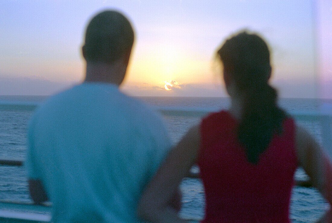Couple looking at setting sun, Cruise ship Aida, Caribbean, America