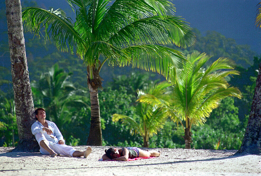 Young couple lying at Maracas Bay, Trinidad, Caribbean