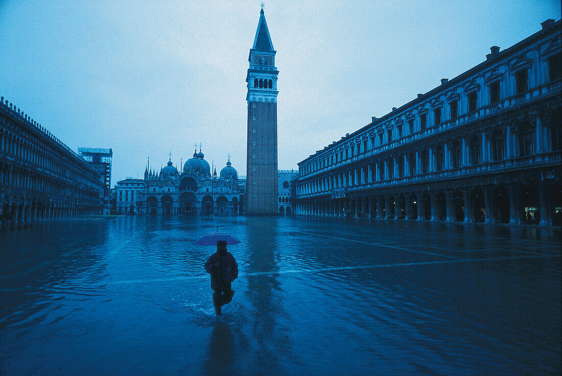 Man with umbrella at St. Marc's square at floodwaters, Venice, Italy, Europe