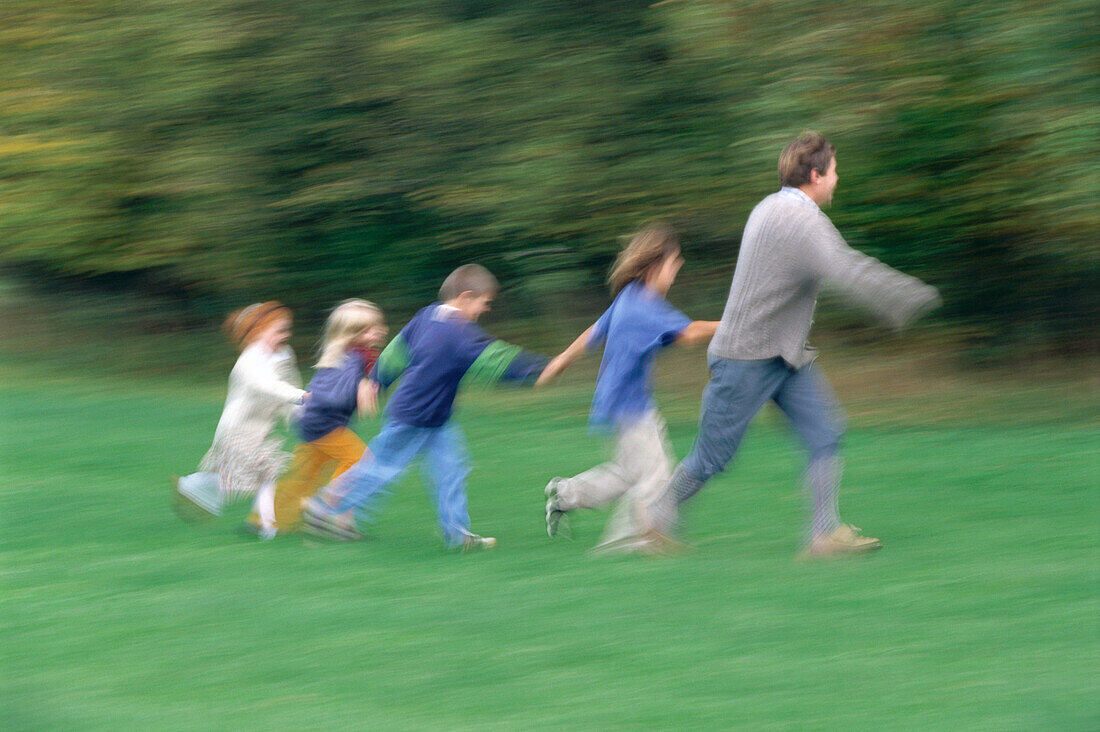 Mann und Kinder, rennen auf Wiese Bayern, Deutschland