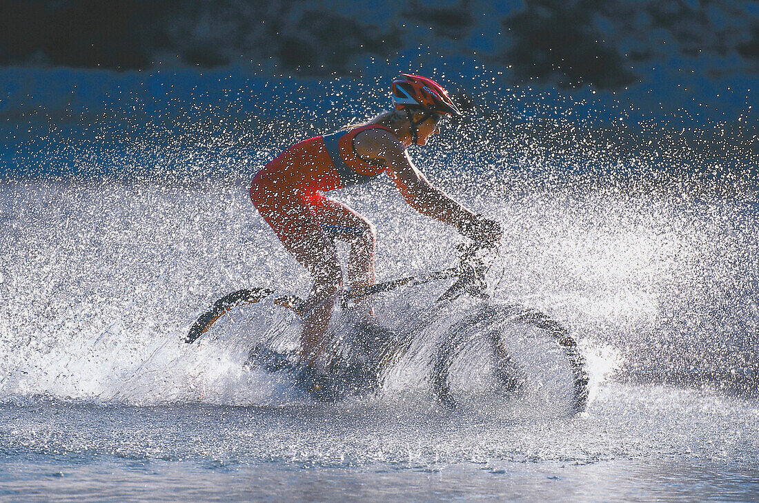 Woman cycling through water