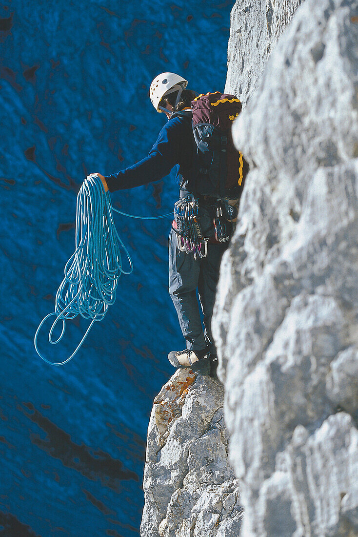 Climber with rope on rock face