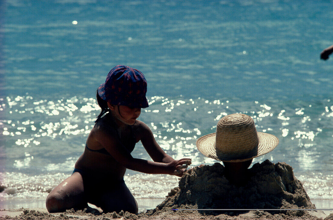 Kind gräbt Mutter ein, Strandurlaub