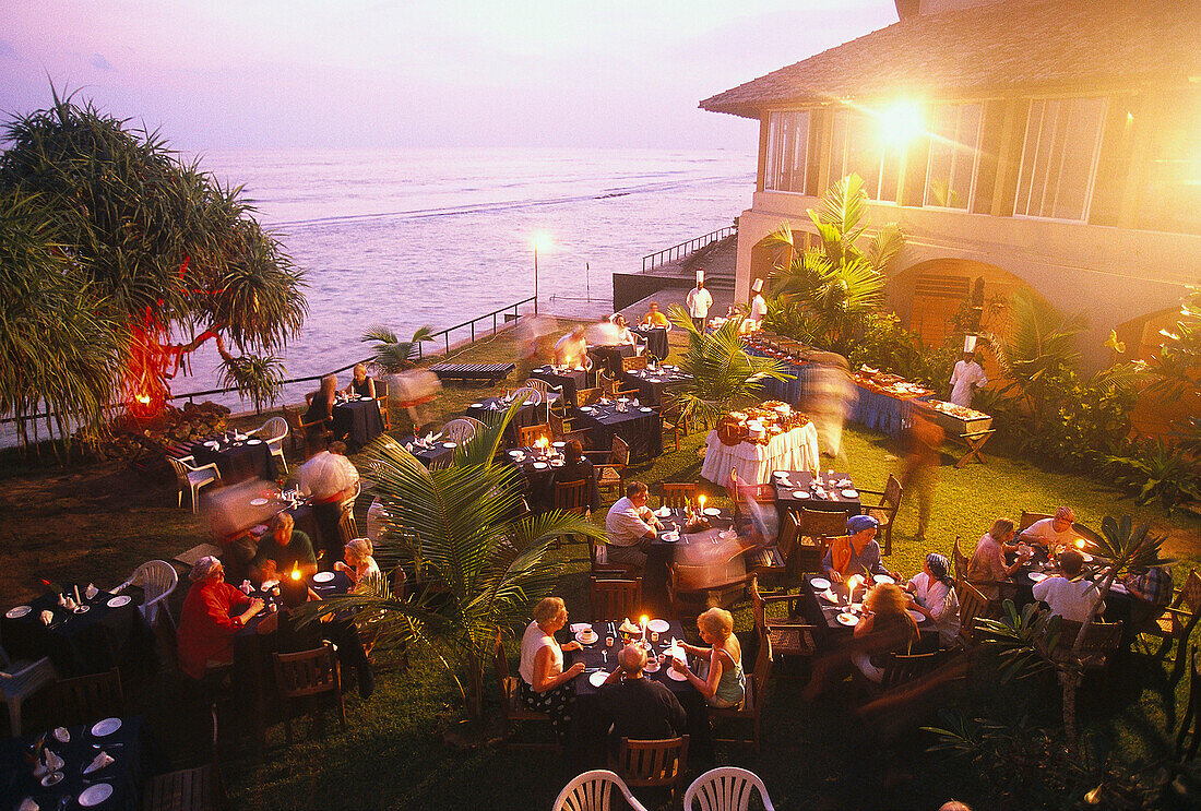 Guests enjoying an evening meal in the garden of Ayuveda Hotel Paragon, Galle, Sri Lanka
