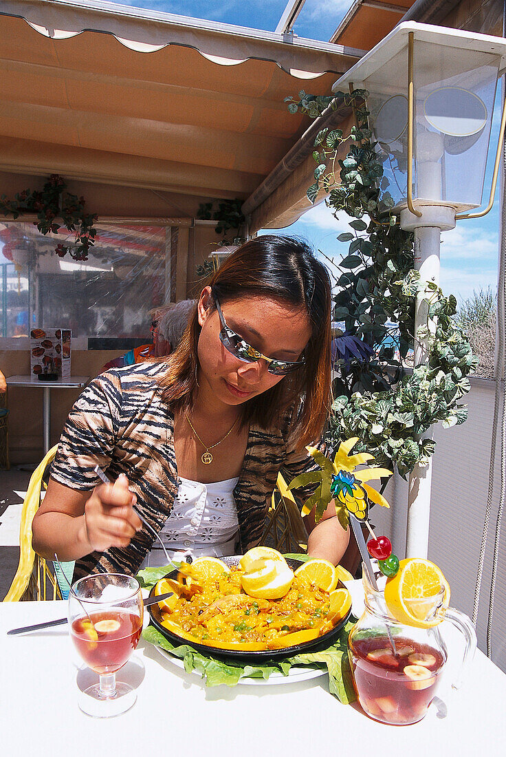 Woman enjoying a meal and a cocktail at a restaurant, Playa del Ingles, Gran Canaria, Canary Islands, Spain