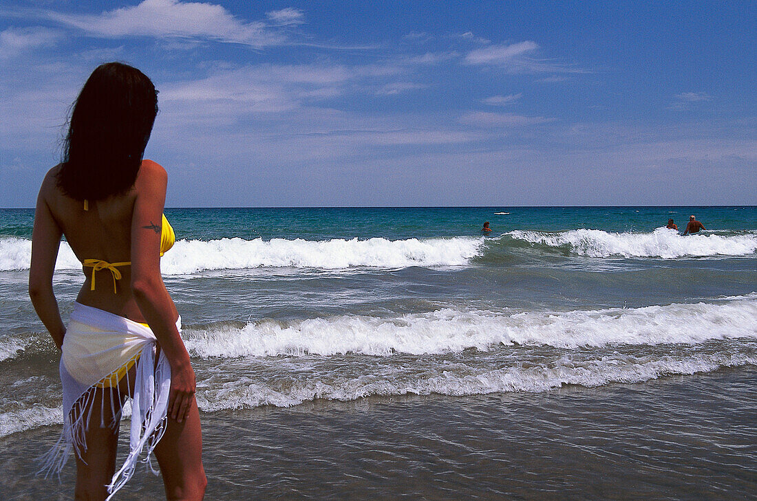 Woman in a bikini watching the surf, Playa del Ingles, Gran Canaria, Canary Islands, Spain
