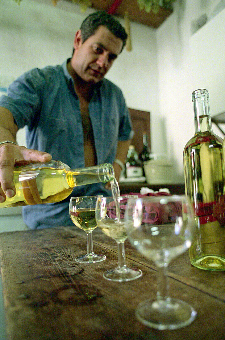 Weinprobe, ein älterer Mann giesst Weißwein in Gläser, Cinque Terre, Ligurien, Italien, Europa