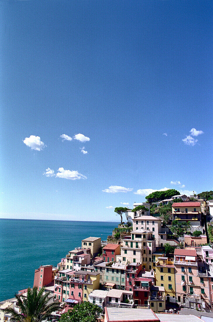 Blick auf ein Dorf am Meer unter blauem Himmel, Riomaggiore, Cinque Terre, Ligurien, Italien, Europa