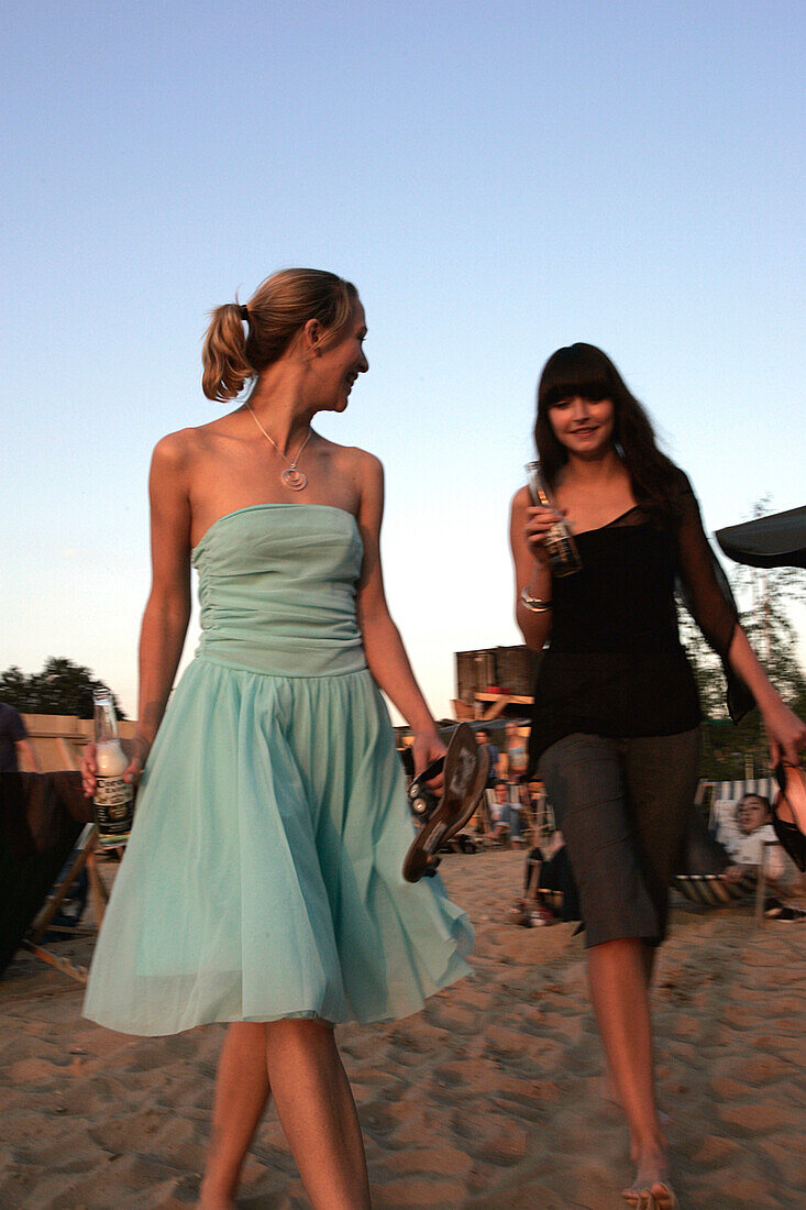 Two young women at a beach bar along the Spree, near Oberbaumbruecke, Berlin, Germany