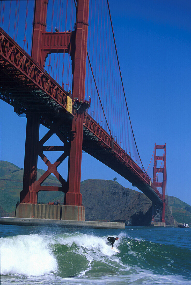 Surfer vor der Golden Gate Bridge unter blauem Himmel, San Francisco, Kalifornien, USA, Amerika