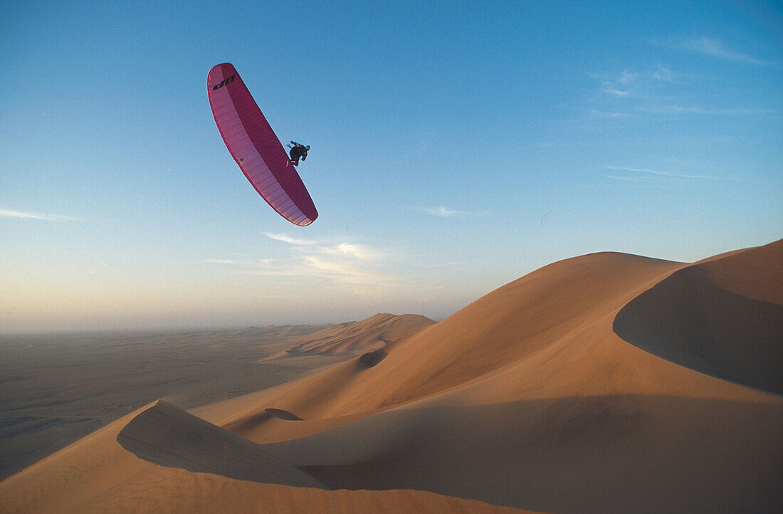 Paragliding über Sanddünen in der Wüste von Namibia, Afrika
