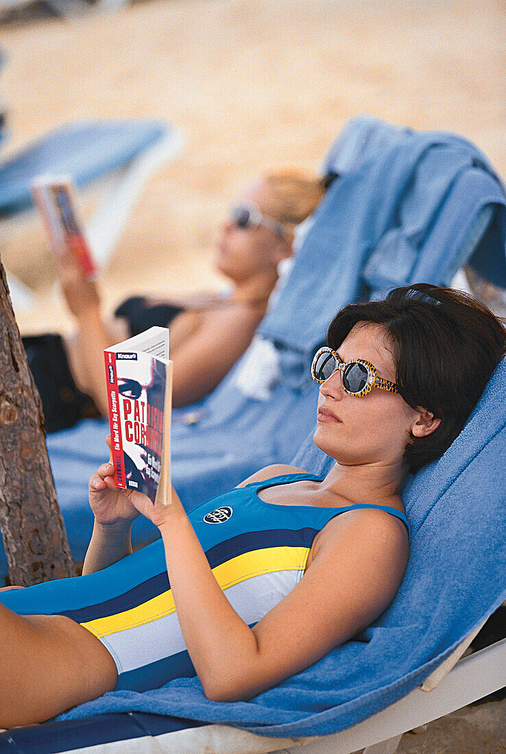 Frau, beim Lesen am Strand