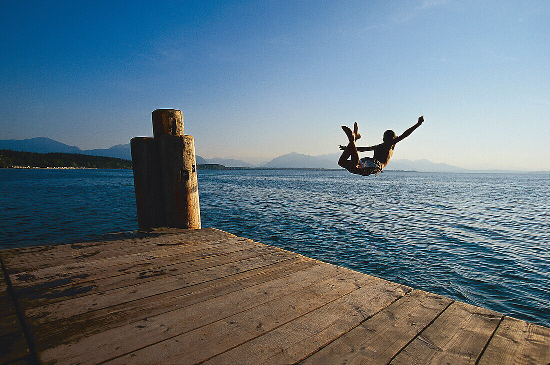 Man jumping from a jetty into the lake, Chieming, Chiemsee, Upper Bavaria