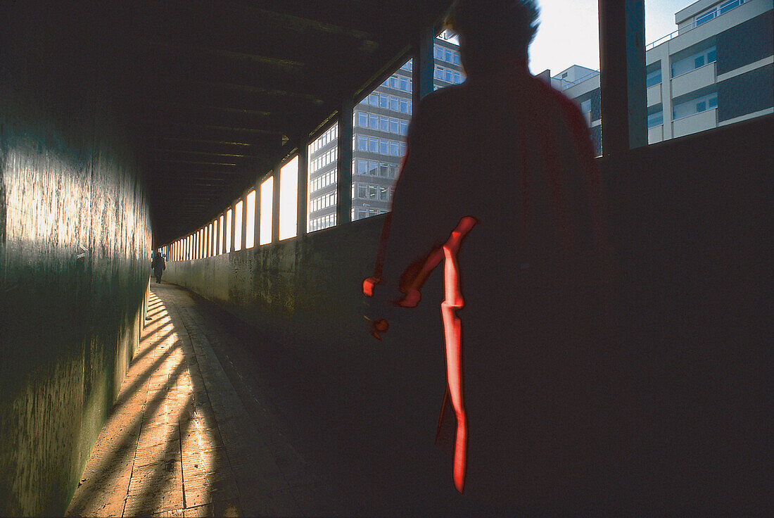 Woman walking through a building site tunnel, Bremen City, Germany