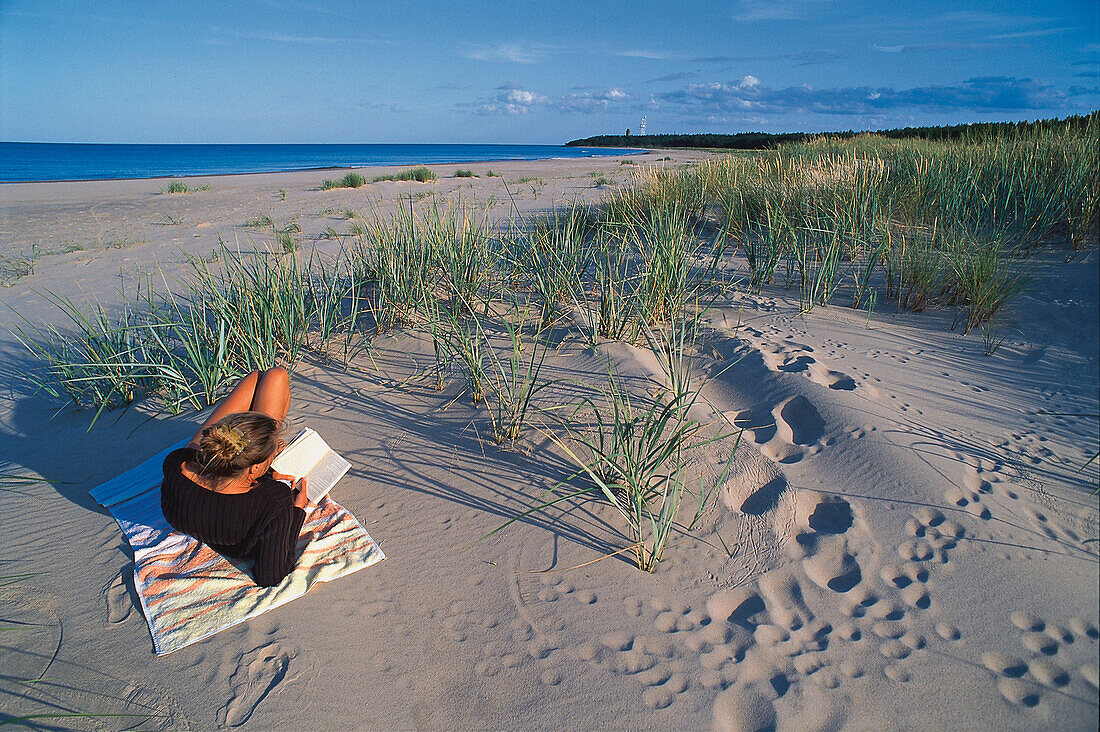 Frau liest am Strand, Nordostküste, Insel Farö, Gotland, Schweden