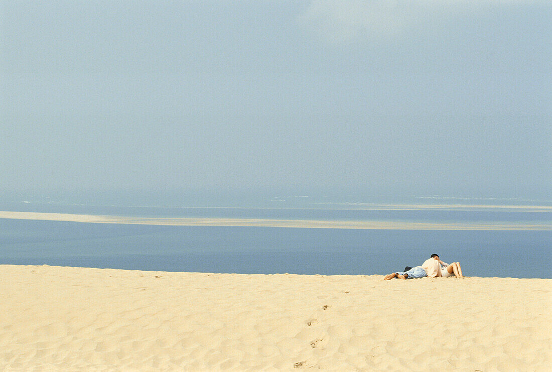 Couple soaking up the sun, sunbathing, The Great Dune of Pilat, Dune de Pilat, Aquitaine, France