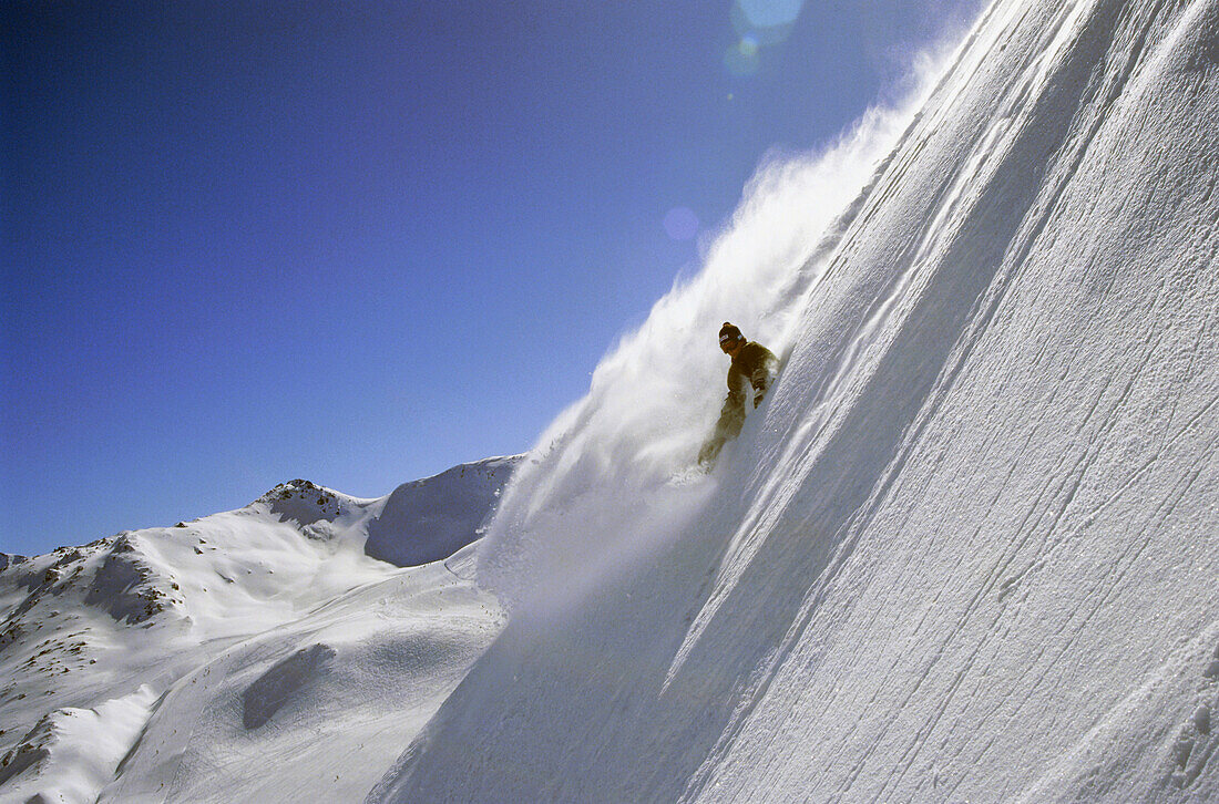 Snowboarder rast verschneiten Berg hinunter, Hochfügen, Österreich
