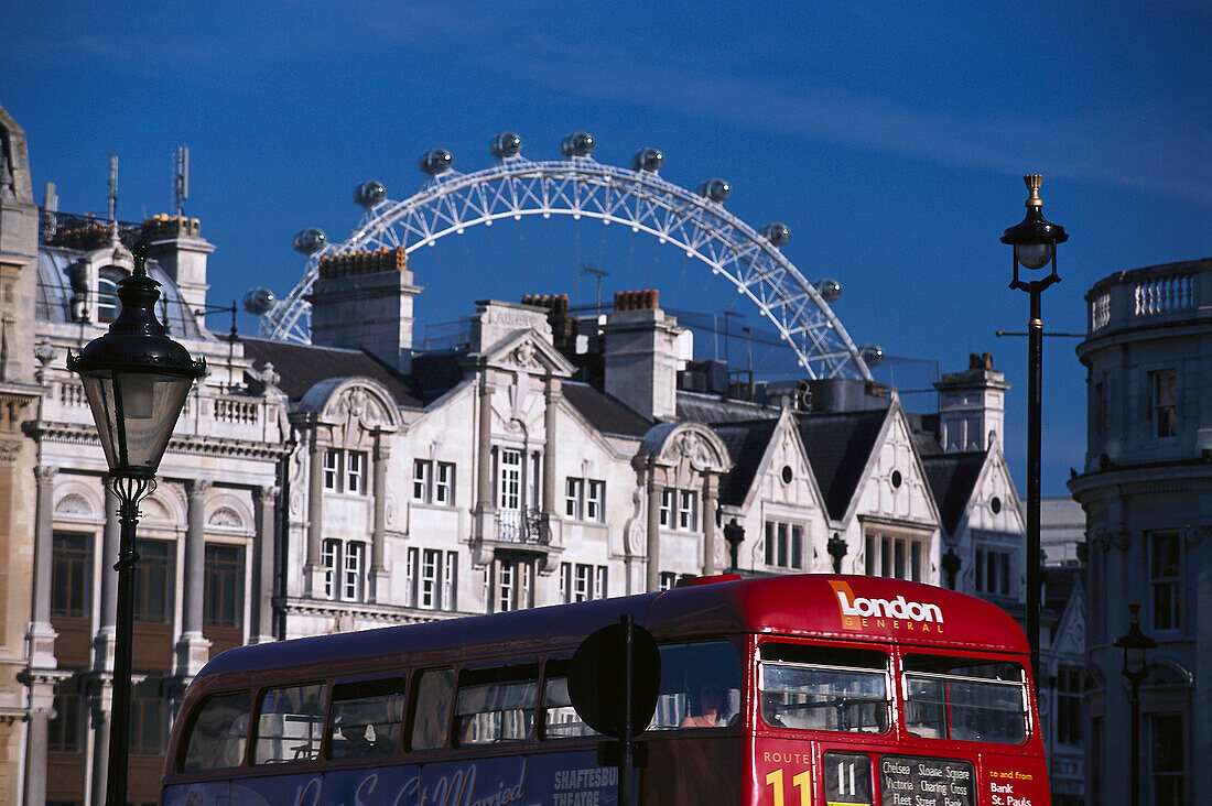 Street of London with a red bus and London Eye hovering above houses, London, England, Great Britain