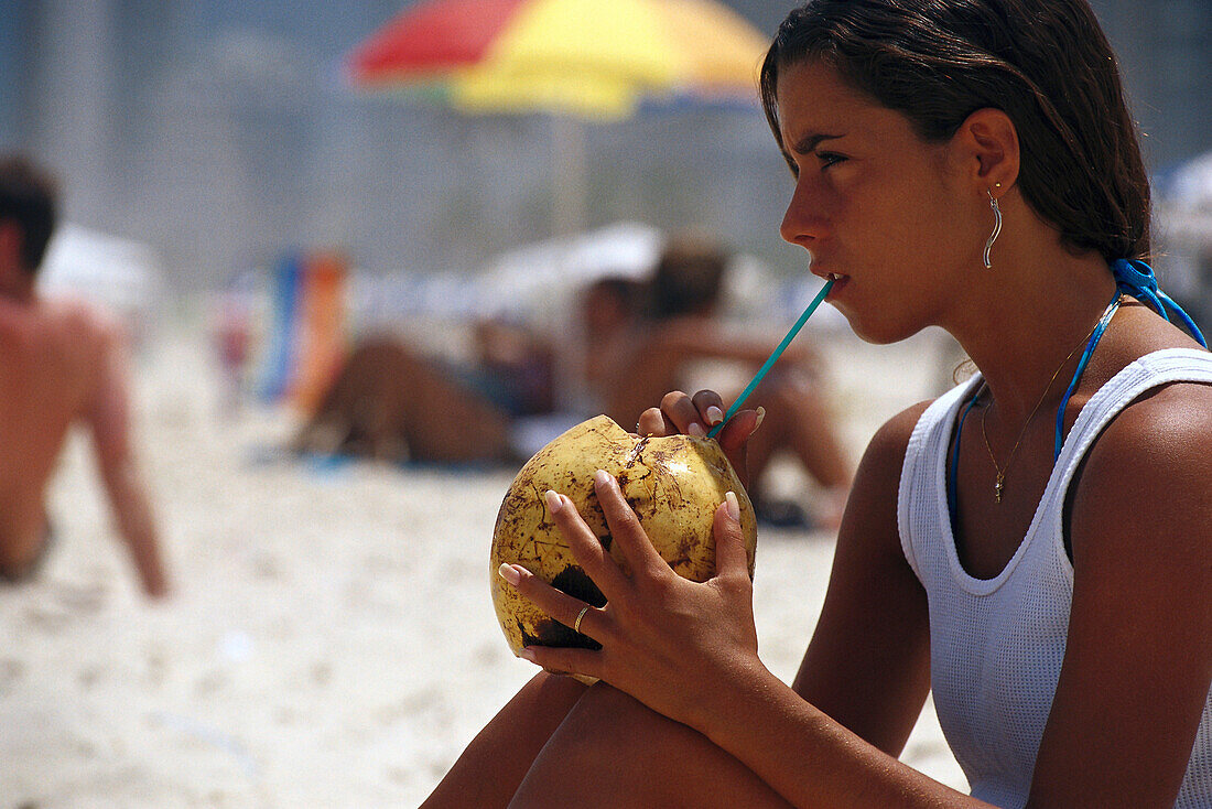 Mädchen trinkt Kokosmilch am Ipanema Strand, Rio de Janeiro, Brasilien, Südamerika, Amerika