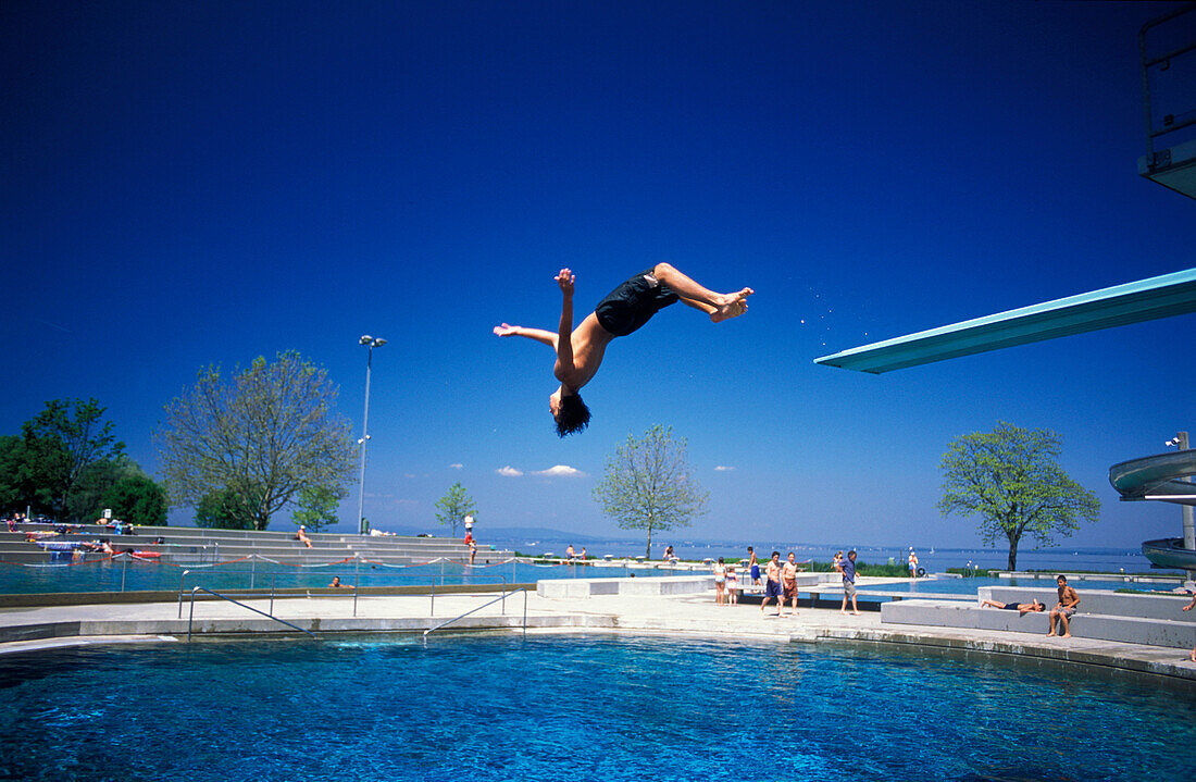 Boy jumping into swimming pool, Lake Constance, Arbon, Switzerland, Europe