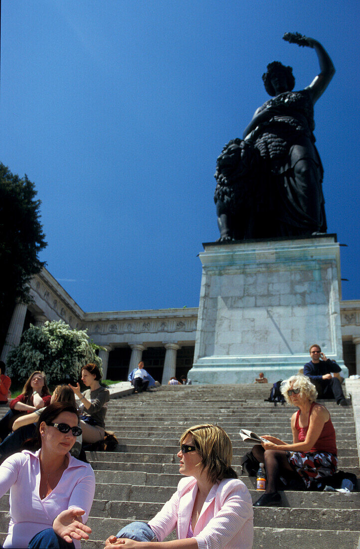 People sitting on stairs beneath Bavaria statue, Theresienwiese, Munich, Bavaria, Germany, Europe