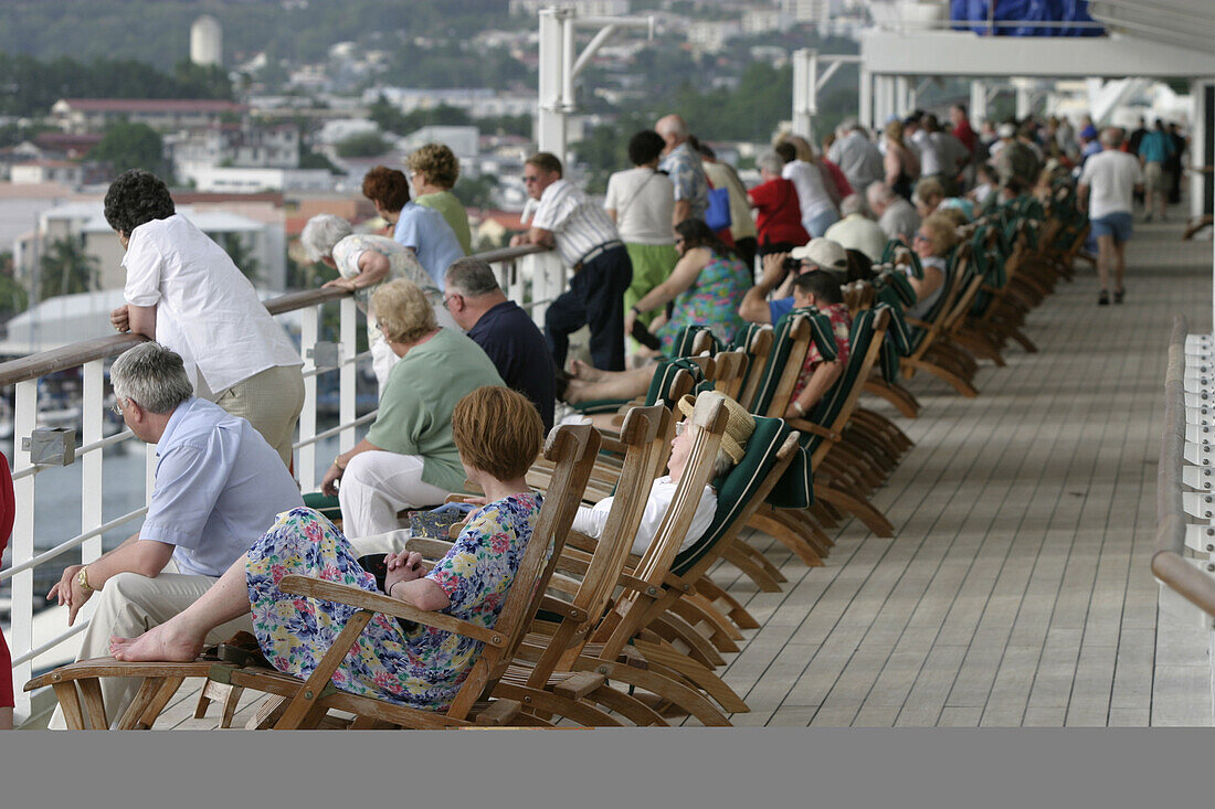 Queen Mary 2, Cast off from Fort-de-France, Queen Mary 2, QM2 Anleger fuer Kreuzfahrtschiffe im Hafen von Fort de France, Martinique. Passagiere beobachten auf Deck 07 das Ablegen des Schiffes.