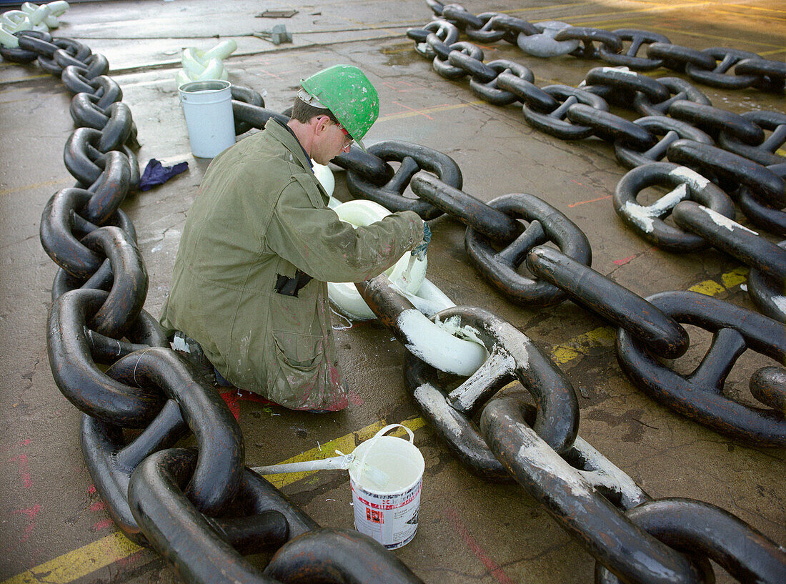 Arbeiter streicht die Ankerkette weiß, Trockendock, Queen Mary 2, Saint-Nazaire, Frankreich