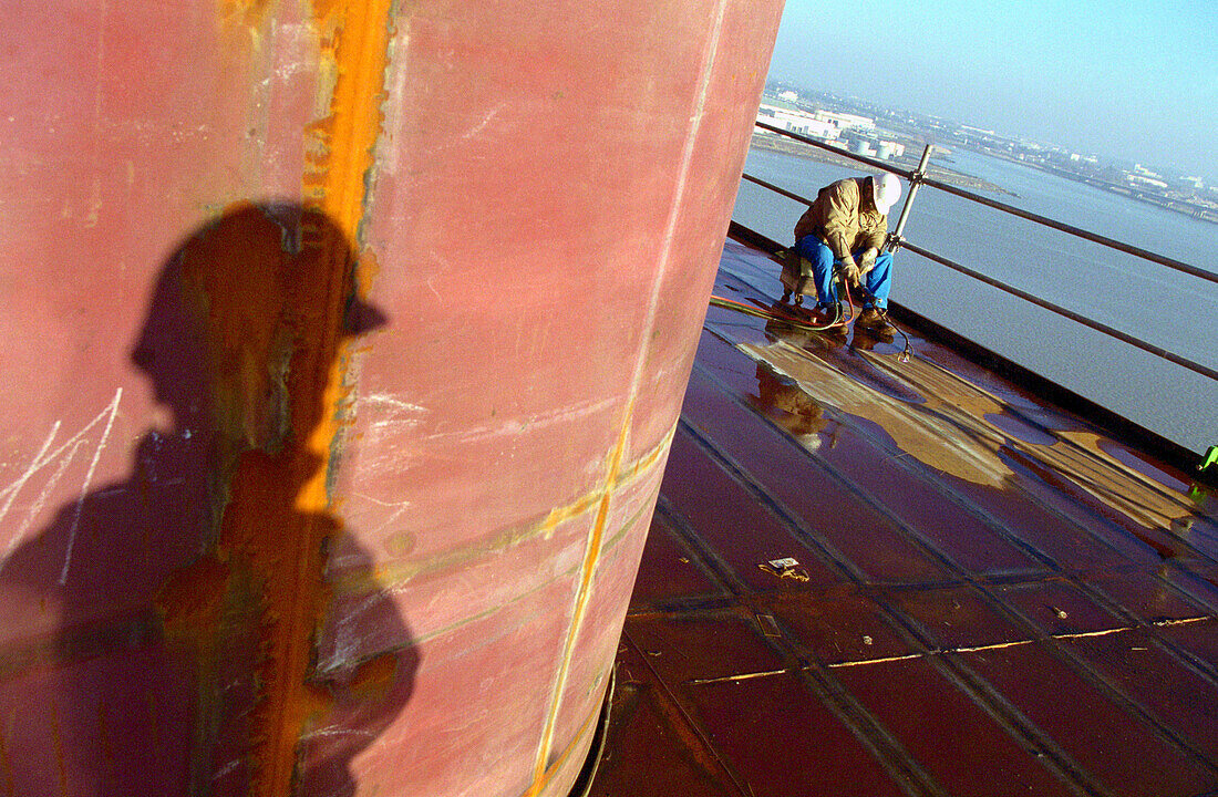 Worker and shadow, dry dock, Queen Mary 2, Saint-Nazaire, France