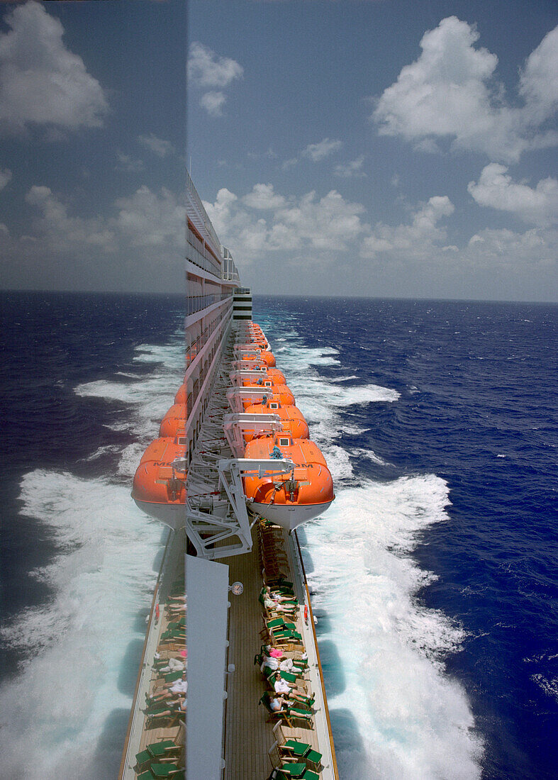 Blick auf Passagiere und Rettungsboote entlang Deck 7 des Kreuzfahrtschiffs Queen Mary 2