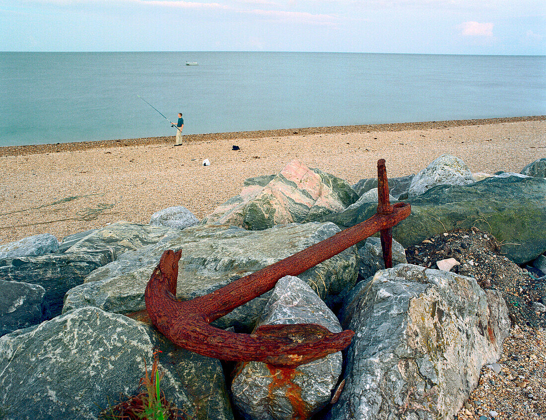 Anchor and angler on beach, Beesands, South England Great Britain