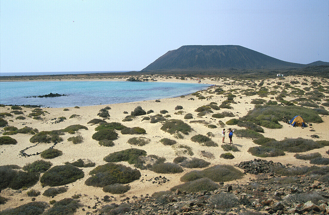 Menschen am Strand in einer Bucht im Sonnenlicht, Isla los Lobos, Fuerteventura, Kanarische Inseln, Spanien, Europa