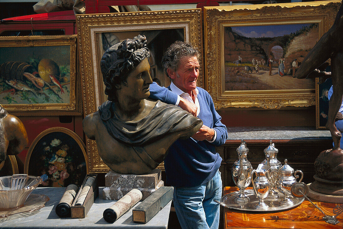 Mature man leaning at antique bust at the flea market, Porta Portese, Rome, Italy, Europe