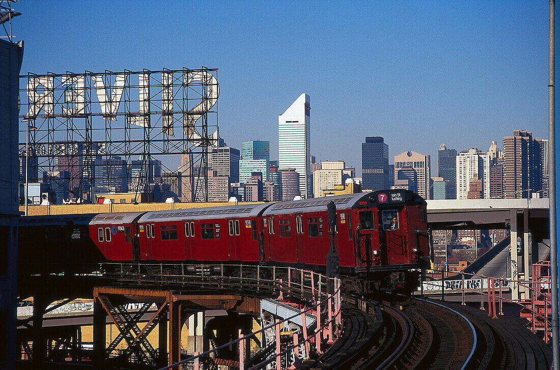 U-Bahn fährt über eine Brücke unter wolkenlosem Himmel, Queens, Manhattan, New York, USA, Amerika