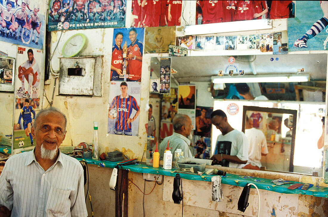 Old man at barber`s, people in shop