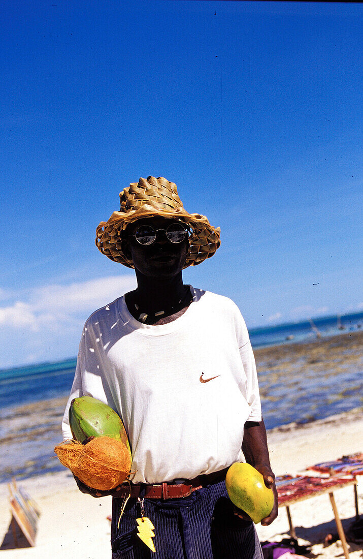 Black men selling coconuts, people vendor on beach